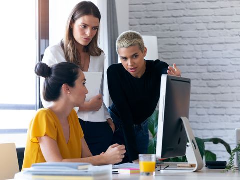 Drei Frauen beraten sich vor einem Computer